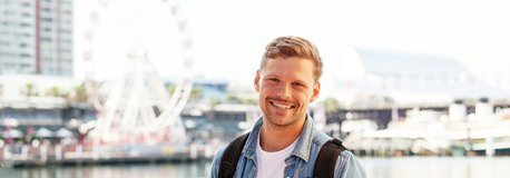 Smiling man outside harbour in background